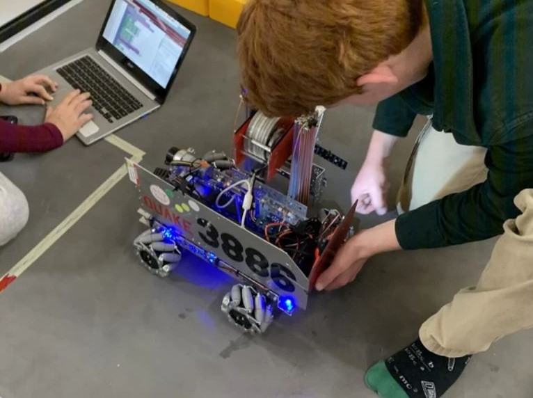 Robotics team members test their creation.