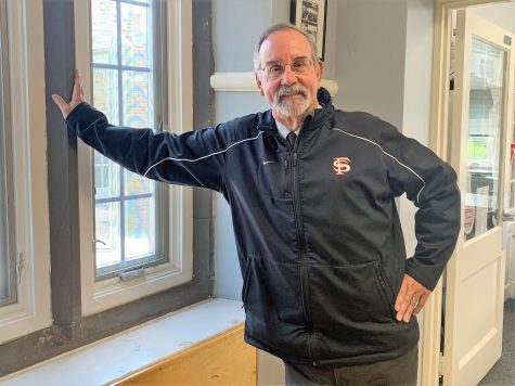 Jon Garman, beloved Friends History teacher, former Athletic Director and 12th Grade Dean, and now Interim Upper School Head, stands in front of his office.