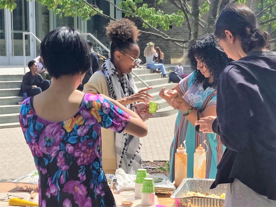 Juniors Ashlee Carpenter and Shirene Gehawi sample foods from the Asian Student Union booth, run by sophomores Mai Bolster and Louisa Sanchez, on Friends School's second annual Culture Day.