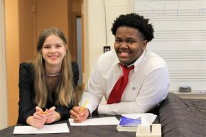 Alice Riley and Braxton Spruel pose for a photo in the choral room, while preparing for the spring choral concert.