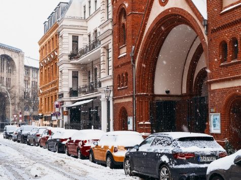 Cars line a snowy street in Berlin. 