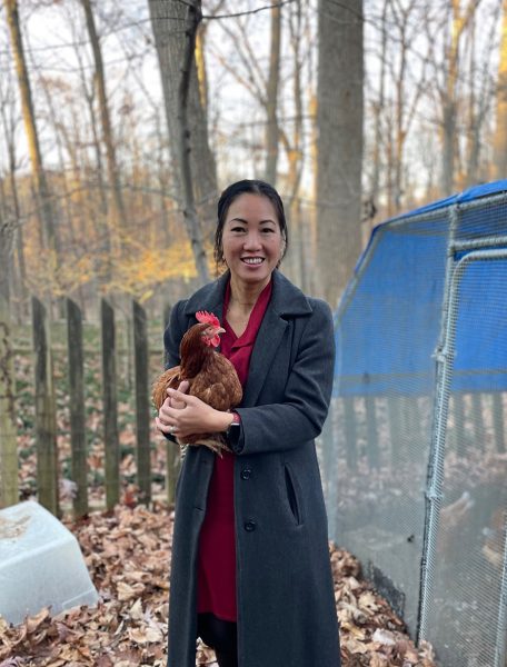 Chemistry teacher Hoa Cost poses with one of her familys chickens in December, 2023.