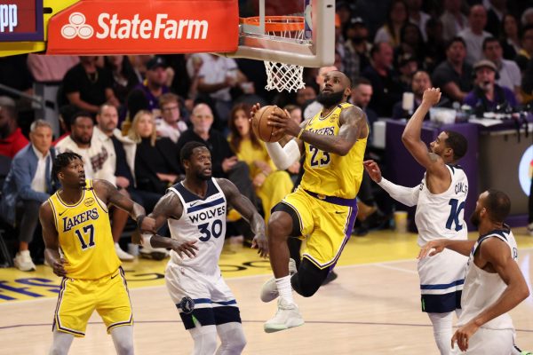 Los Angeles Lakers forward LeBron James goes to the basket between Minnesota Timberwolves forward Julius Randle and guard Mike Conley, during game two of the 2024 NBA Playoffs.