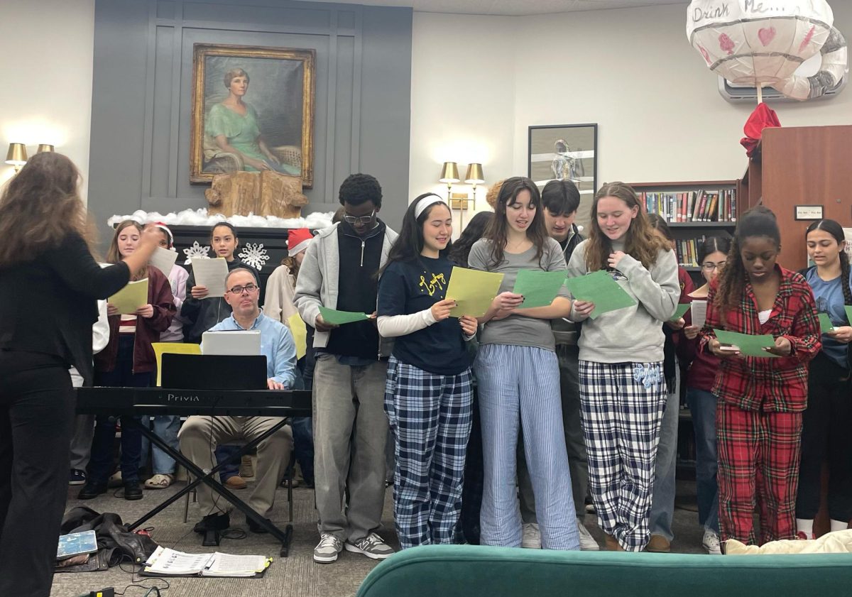 Upper School French students (in PJs for Pajama Day) joined the Apollos to sing French Christmas carols for Ms. Koniezhny.